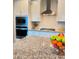 Close up on kitchen island with granite countertop, stainless appliances, and white cabinets in the background at 18808 W Solano Dr, Litchfield Park, AZ 85340