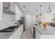 Bright kitchen with white cabinets, stainless appliances, a gas cooktop, and a large center island at 18808 W Solano Dr, Litchfield Park, AZ 85340
