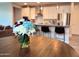 Close-up of a bouquet on a wooden table, with a view of the modern kitchen featuring stainless steel appliances at 18808 W Solano Dr, Litchfield Park, AZ 85340
