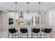 Modern kitchen boasts stainless steel appliances, granite countertops, pendant lighting, and a breakfast bar with seating at 18808 W Solano Dr, Litchfield Park, AZ 85340