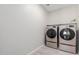 This laundry room features modern washer and dryer units with tiled floors at 18808 W Solano Dr, Litchfield Park, AZ 85340