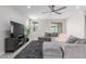 Spacious living room showcases a gray sectional, modern TV stand with fireplace, and view of the backyard at 18808 W Solano Dr, Litchfield Park, AZ 85340