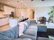 Open-concept living room showcases a large gray sectional, connecting to the modern kitchen with bar seating at 18808 W Solano Dr, Litchfield Park, AZ 85340