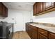 Laundry room with wooden cabinetry, granite countertops, washer, and dryer at 18873 N 94Th Way, Scottsdale, AZ 85255
