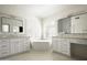 Bright main bathroom featuring a soaking tub, dual vanity sinks, and plantation shutters at 18873 N 94Th Way, Scottsdale, AZ 85255