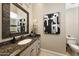 Elegant bathroom features stylish vanity with brown granite countertop and decorative mirror at 18927 N 101St St, Scottsdale, AZ 85255