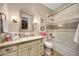 Well-lit bathroom with a shower-tub combo, decorative XO art, and vanity with marble countertop at 18927 N 101St St, Scottsdale, AZ 85255