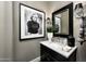 Chic powder room boasts modern black vanity, marble countertop, and unique artwork at 18927 N 101St St, Scottsdale, AZ 85255