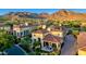 An aerial view shows the backyard and patio area, with seating, a fire pit, landscaping, and mountain views at 18927 N 101St St, Scottsdale, AZ 85255