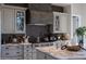 Chef's kitchen boasts Wolf range, custom vent hood, and marble countertops at 18927 N 101St St, Scottsdale, AZ 85255