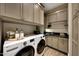 Laundry room with modern appliances, ample storage cabinets, and a utility sink at 18927 N 101St St, Scottsdale, AZ 85255