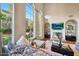 Bright living room featuring tall windows, a fireplace, comfortable seating, and an airy atmosphere at 18927 N 101St St, Scottsdale, AZ 85255