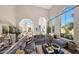 Bright, open living room with a large sectional sofa, high ceilings, and large arched windows offering natural light at 18927 N 101St St, Scottsdale, AZ 85255