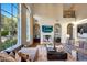 Cozy living room with a fireplace, tall windows with outdoor views, and comfortable seating at 18927 N 101St St, Scottsdale, AZ 85255
