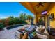 This covered patio features a cozy seating area with a fire pit and TV, plus a small private pool and lush landscaping at 18927 N 101St St, Scottsdale, AZ 85255