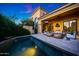 A view of the pool from the corner of the home shows the private pool with access to the covered patio with TV at 18927 N 101St St, Scottsdale, AZ 85255