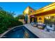 A view of the pool from the corner of the home shows the private pool with access to the covered patio with TV at 18927 N 101St St, Scottsdale, AZ 85255