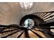 Unique birds-eye view of elegant spiral staircase with chandelier above at 18927 N 101St St, Scottsdale, AZ 85255