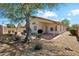 Charming backyard featuring desert landscaping, mature tree, and covered patio with brick accents at 19127 N 79Th Dr, Glendale, AZ 85308