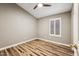Cozy bedroom features a ceiling fan, neutral paint, wood-look floors, and a window with shutters at 19127 N 79Th Dr, Glendale, AZ 85308