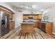 Well-lit kitchen featuring wood cabinetry, stainless steel appliances, and a central island at 19127 N 79Th Dr, Glendale, AZ 85308