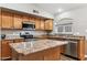 Kitchen with stainless steel appliances, wood cabinets, and an island with countertop space at 19127 N 79Th Dr, Glendale, AZ 85308