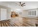 Open-concept living room and kitchen, laminate floors, stainless appliances, ceiling fan, and modern lighting at 19127 N 79Th Dr, Glendale, AZ 85308