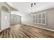 Bright living room featuring wood-look flooring, plantation shutters, pendant lights, and vaulted ceilings at 19127 N 79Th Dr, Glendale, AZ 85308