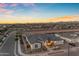 An aerial view of luxury home showcasing landscape lighting and mature landscaping; mountains in the background at 20426 E Arroyo Verde Dr, Queen Creek, AZ 85142