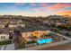 Aerial view showcasing a backyard oasis with a sparkling pool, covered patio, and mountain views at 20426 E Arroyo Verde Dr, Queen Creek, AZ 85142