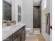 Elegant bathroom with dark wood cabinets, a quartz countertop, and a glass enclosed shower at 20426 E Arroyo Verde Dr, Queen Creek, AZ 85142