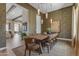 Formal dining room with a large wood table, seating for ten, modern lighting, and textured wallpaper at 20426 E Arroyo Verde Dr, Queen Creek, AZ 85142