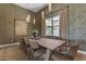 Elegant dining room featuring a large wood table, modern light fixtures, and stylish wallpaper at 20426 E Arroyo Verde Dr, Queen Creek, AZ 85142