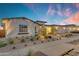 Inviting home exterior features a well-manicured yard with desert landscaping, and a three-car garage at 20426 E Arroyo Verde Dr, Queen Creek, AZ 85142