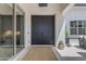 Elegant front entrance with a dark double door, neutral rug, and inviting outdoor seating at 20426 E Arroyo Verde Dr, Queen Creek, AZ 85142
