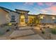 Charming front entrance with stone pathway, desert landscaping, and an inviting porch with outdoor seating at 20426 E Arroyo Verde Dr, Queen Creek, AZ 85142