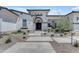 Front exterior featuring desert landscaping and a grand arched entryway with stone pavers at 20426 E Arroyo Verde Dr, Queen Creek, AZ 85142