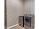 Modern laundry room with stainless steel washer and dryer and stylish wallpaper at 20426 E Arroyo Verde Dr, Queen Creek, AZ 85142
