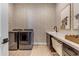 A modern laundry room has patterned wallpaper, front load laundry and storage space at 20426 E Arroyo Verde Dr, Queen Creek, AZ 85142