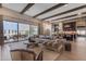 Bright living room with exposed beams, large sofa, and an open floor plan leading to the kitchen at 20426 E Arroyo Verde Dr, Queen Creek, AZ 85142