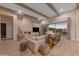 A cozy living room featuring a stone fireplace, wood beams, and elegant furniture at 20426 E Arroyo Verde Dr, Queen Creek, AZ 85142