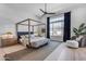 Serene bedroom with a four-poster bed, ceiling fan, and large window with natural light at 20426 E Arroyo Verde Dr, Queen Creek, AZ 85142
