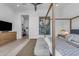 Stylish bedroom featuring a four-poster bed, modern decor, and a view into the ensuite bathroom at 20426 E Arroyo Verde Dr, Queen Creek, AZ 85142