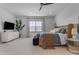 Spacious main bedroom with ceiling fan, dresser, and comfortable seating for relaxing at 20426 E Arroyo Verde Dr, Queen Creek, AZ 85142