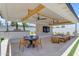 A covered patio has a dining table, chairs, outdoor sofa, ceiling fans, and a TV at 20426 E Arroyo Verde Dr, Queen Creek, AZ 85142