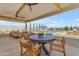 An outdoor dining table overlooks a pool and outdoor seating area with lounge chairs at 20426 E Arroyo Verde Dr, Queen Creek, AZ 85142