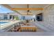 Covered patio with comfortable seating, ceiling fans, stone accent wall, and outdoor TV at 20426 E Arroyo Verde Dr, Queen Creek, AZ 85142