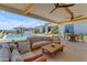 A covered outdoor seating area has views of the swimming pool, lounge chairs, and backyard at 20426 E Arroyo Verde Dr, Queen Creek, AZ 85142