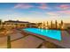 Tranquil backyard features a shimmering pool, a covered outdoor kitchen, mature trees, and lush landscape for the ultimate backyard at 20426 E Arroyo Verde Dr, Queen Creek, AZ 85142