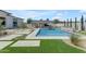 Inviting pool area, complete with a covered outdoor kitchen and lush landscaping at 20426 E Arroyo Verde Dr, Queen Creek, AZ 85142